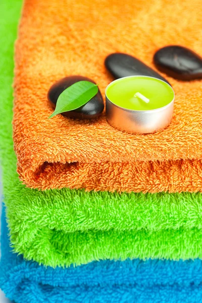 Background of the three multi-colored bath towels, black spa sto — Zdjęcie stockowe