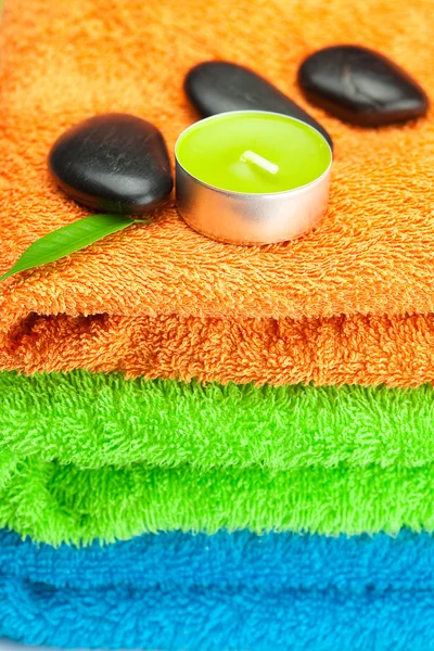 Bakgrund av tre flerfärgade bad handdukar, svart spa sto — Stockfoto