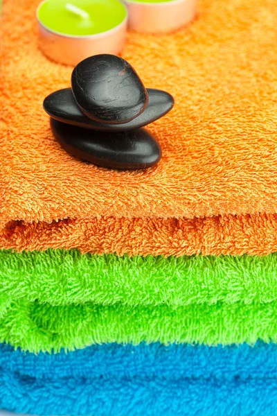 Üç adet çok renkli banyo havlusu, siyah spa sto arka planı — Stok fotoğraf