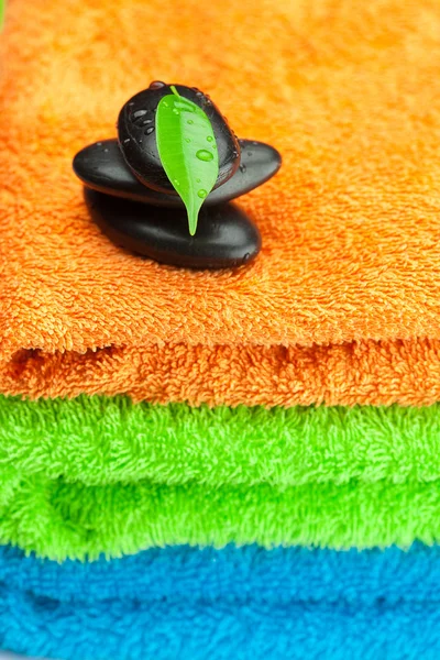 Fondo de las tres toallas de rizo multicolor y spa negro —  Fotos de Stock