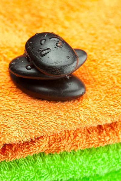 Pietre termali nere distese sull'asciugamano — Foto Stock
