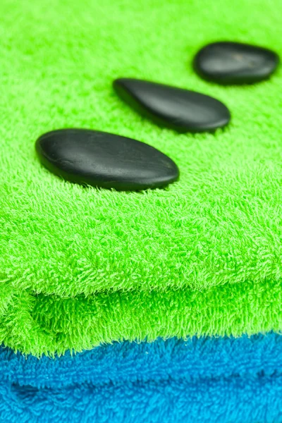 Pedras spa preto deitado sobre a toalha — Fotografia de Stock