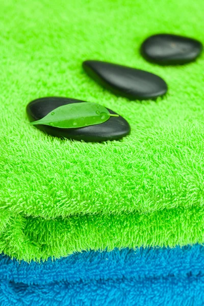 Pedras spa preto deitado sobre a toalha — Fotografia de Stock