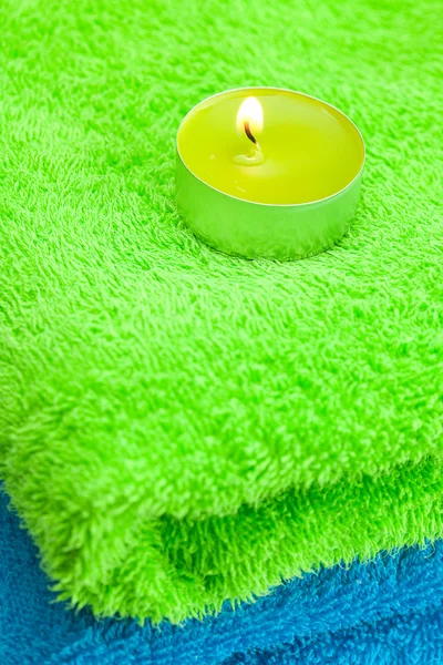 Una candela accesa sdraiata sull'asciugamano — Foto Stock