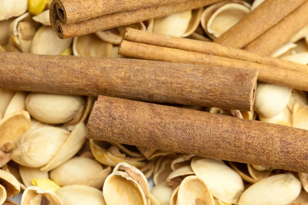 Background from the shell of pistachio nuts and cinnamon sticks — Stock Photo, Image