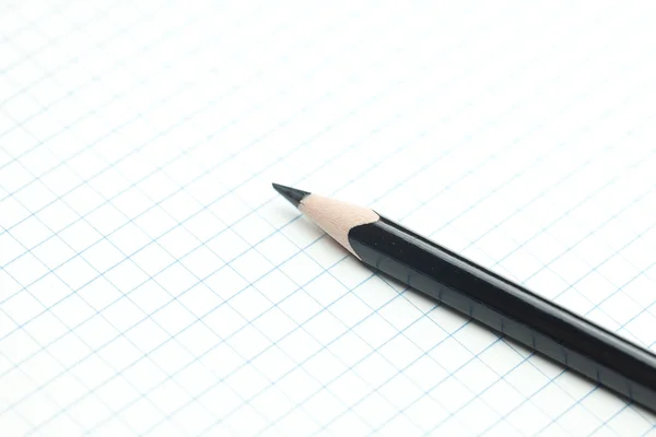Клетчатый ноутбук со спиралью и карандашом — стоковое фото