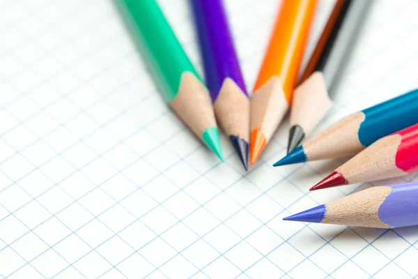 Caderno xadrez com um lápis em espiral e colorido — Fotografia de Stock