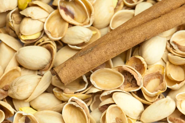 Bakgrund från skalet av pistagenötter och kanelstänger — Stockfoto
