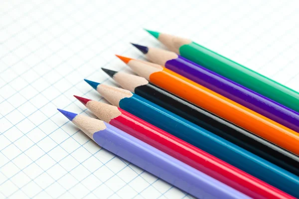 Cuaderno a cuadros con una espiral y lápiz de colores — Foto de Stock