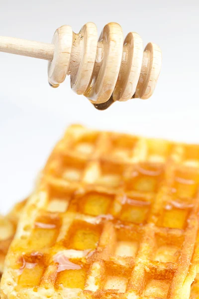 Köstliche belgische Waffeln und kleben an Honig isoliert auf weiß — Stockfoto