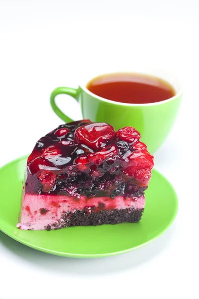 Hermoso pastel con bayas en un plato y una taza de té aislado —  Fotos de Stock