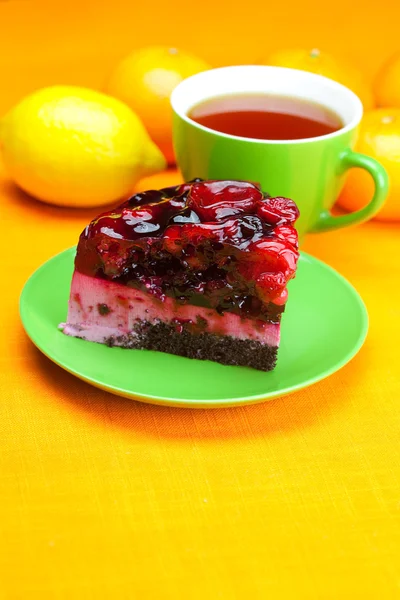 Hermoso pastel con bayas en un plato y una taza de té en el o —  Fotos de Stock