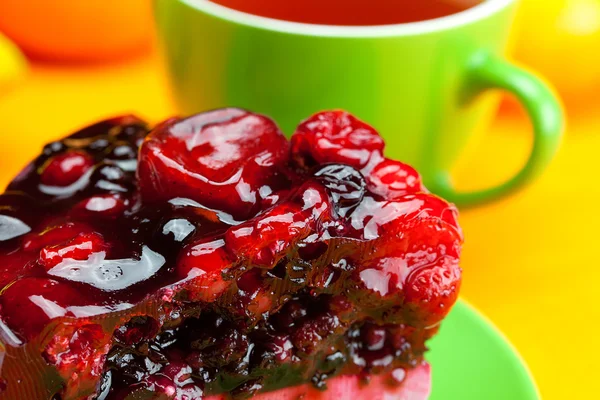 Krásný dort s ovocem na desce a šálek čaje na o — Stock fotografie