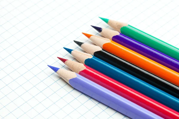 Cuaderno a cuadros con una espiral y lápiz de colores — Foto de Stock