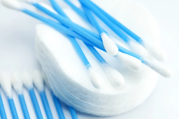 Mavi üzerine beyaz izole pamuklu ped ve temizleme fırçası — Stok fotoğraf