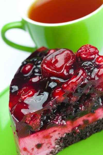 Beautiful cake with berries on a plate and a cup of tea isolated — Stock Photo, Image