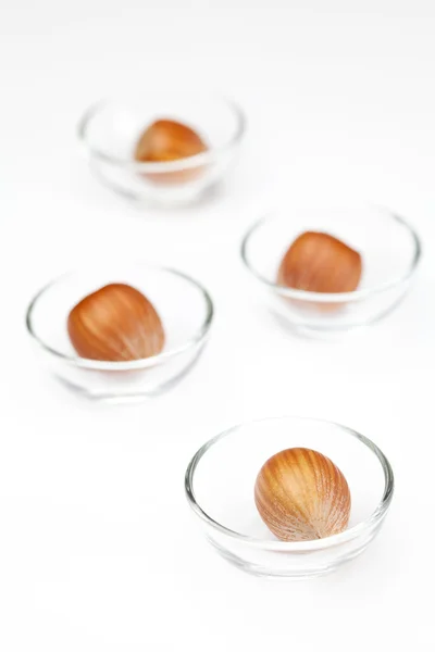 Noten in miniatuur glazen kommen geïsoleerd op wit — Stockfoto