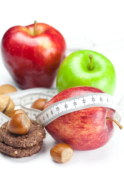 Apple, nuts, cookies and measure tape isolated on white — Stock Photo, Image