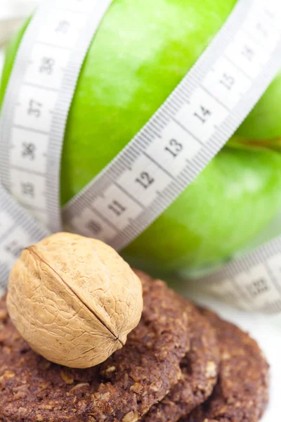 stock image Apple, nuts, cookies and measure tape isolated on white