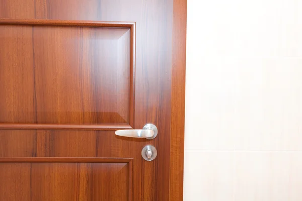 Porta de madeira com uma alça em um quarto branco — Fotografia de Stock