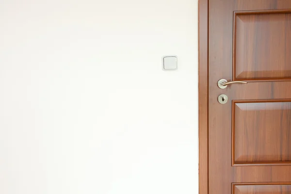 Houten deur met een handvat in een witte kamer — Stockfoto