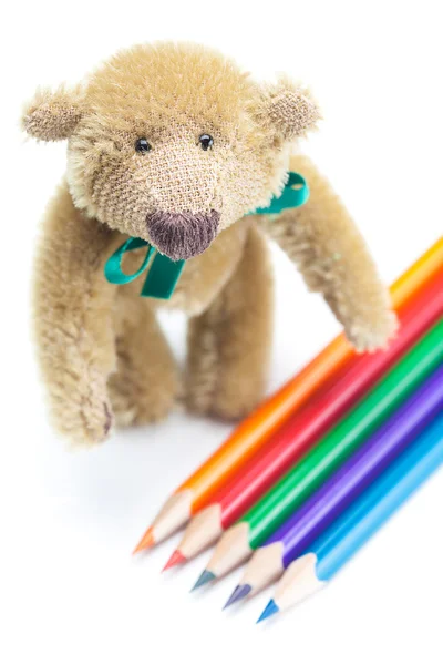 Oyuncak ayı ve renkli kalemler üzerinde beyaz izole — Stok fotoğraf