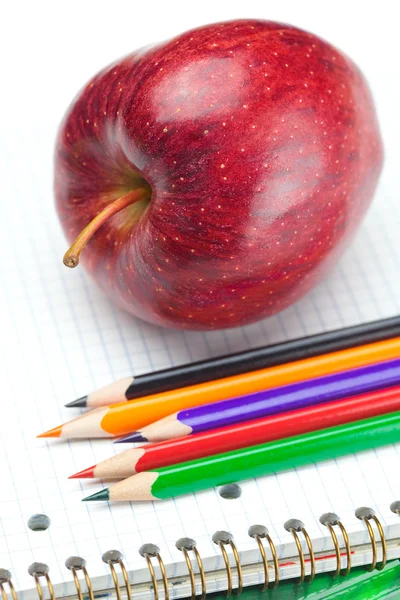 Μήλο, τετράδια και μολύβια που απομονώνονται σε λευκό — Φωτογραφία Αρχείου