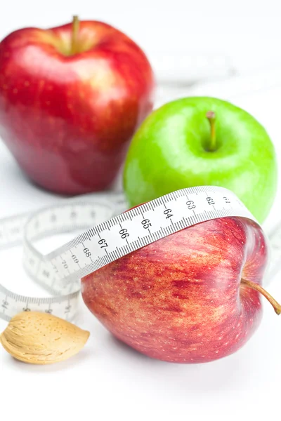 Elma, fındık ve ölçü bandı üzerinde beyaz izole — Stok fotoğraf