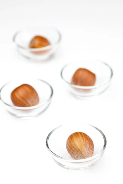 Noix dans des bols en verre miniatures isolés sur blanc — Photo