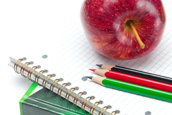 Apple, defter ve kalemler üzerinde beyaz izole — Stok fotoğraf