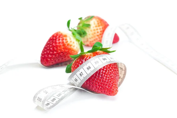 Duże soczysty czerwony dojrzałe truskawki, orzechy i miara na białym tle o taśmy — Zdjęcie stockowe