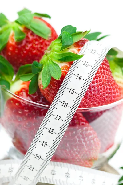 Grandes fraises mûres rouges juteuses dans un bol en verre et mesurer le ruban adhésif — Photo