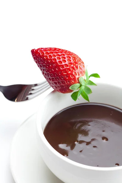 Melted chocolate in a cup, fork and strawberries isolated on whi — Stock Photo, Image