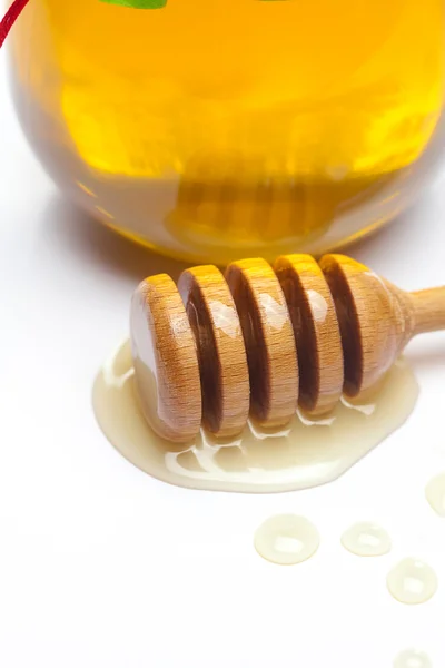 Stick to hohey and jar of honey isolated on white — Stock Photo, Image
