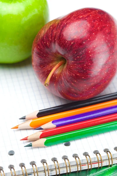 Manzana, cuadernos y lápices aislados en blanco — Foto de Stock
