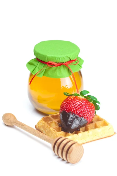 Morangos maduros suculentos grandes em chocolate, um jarro de mel e cera — Fotografia de Stock