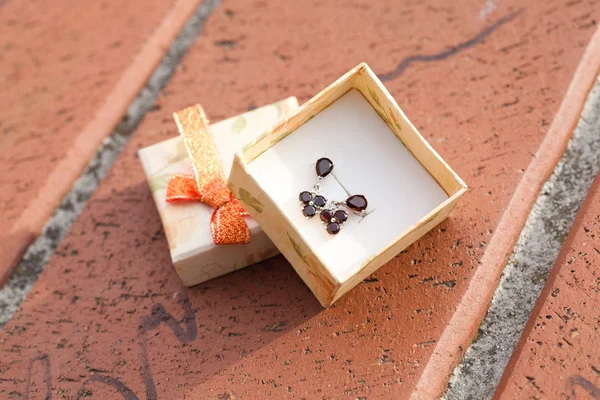 Small box with a garnet earrings outdoor — Stock Photo, Image