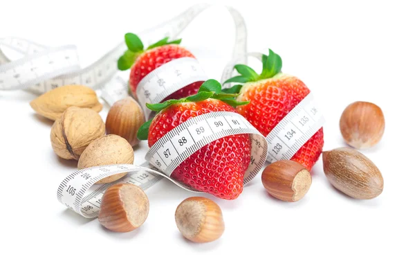 stock image Big juicy red ripe strawberries,nuts and measure tape isolated o