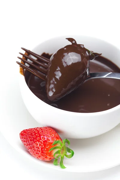 Melted chocolate in a cup, fork and strawberries isolated on whi — Stock Photo, Image