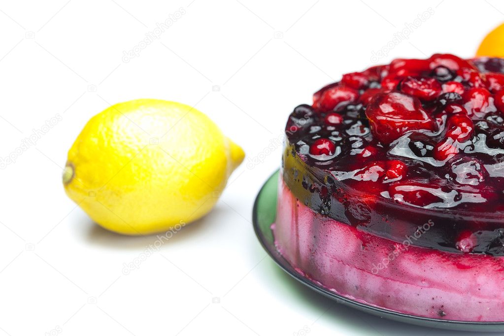 Beautiful cake with berries on a plate and lemon isolated on whi