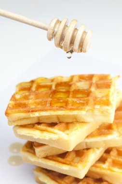 lezzetli Belçika waffle ve sopa üzerinde beyaz izole Bala