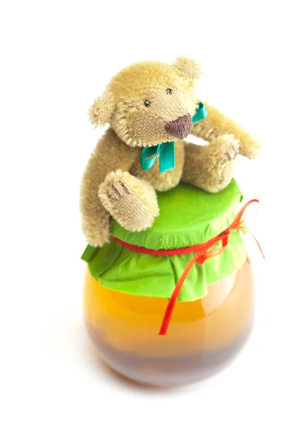 Ursinho de pelúcia e frasco de mel isolado em branco — Fotografia de Stock