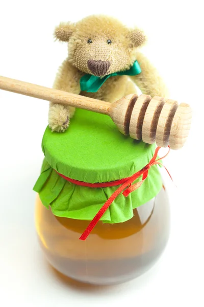 Teddy bear ,stick to hohey and jar of honey isolated on white — Stock Photo, Image