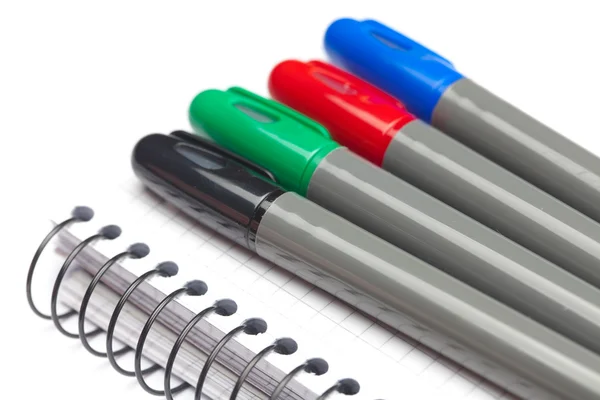 Gekleurde markeringen en een notebook geïsoleerd op wit — Stockfoto