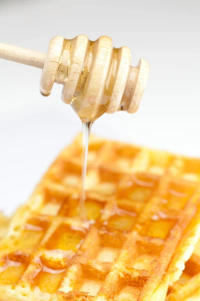 Deliciosos waffles belgas e ficar com mel isolado em branco — Fotografia de Stock