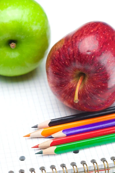 Apfel, Notizbücher und Bleistifte isoliert auf weiß — Stockfoto