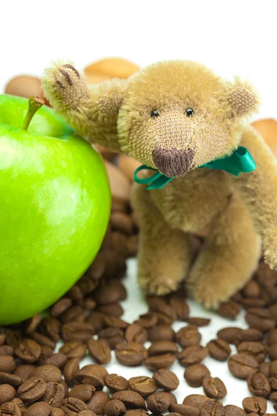 Плюшевый мишка с луком, яблоком и кофейными зёрнами — стоковое фото