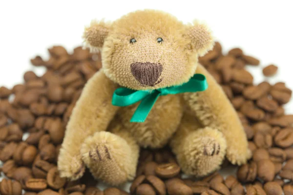 Urso de pelúcia com um arco e grãos de café — Fotografia de Stock