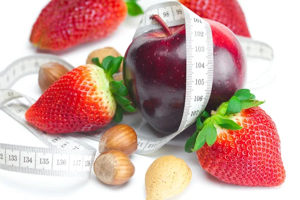 Duże soczysty czerwony dojrzałe truskawki, jabłka, orzechy i isol miary taśmowe — Zdjęcie stockowe