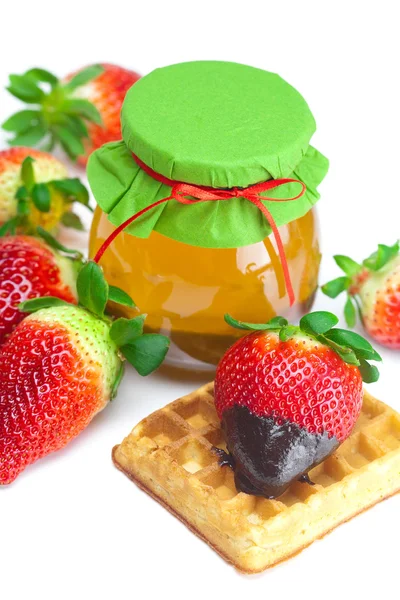 Big juicy ripe strawberries in chocolate, a jar of honey and waf — Stock Photo, Image
